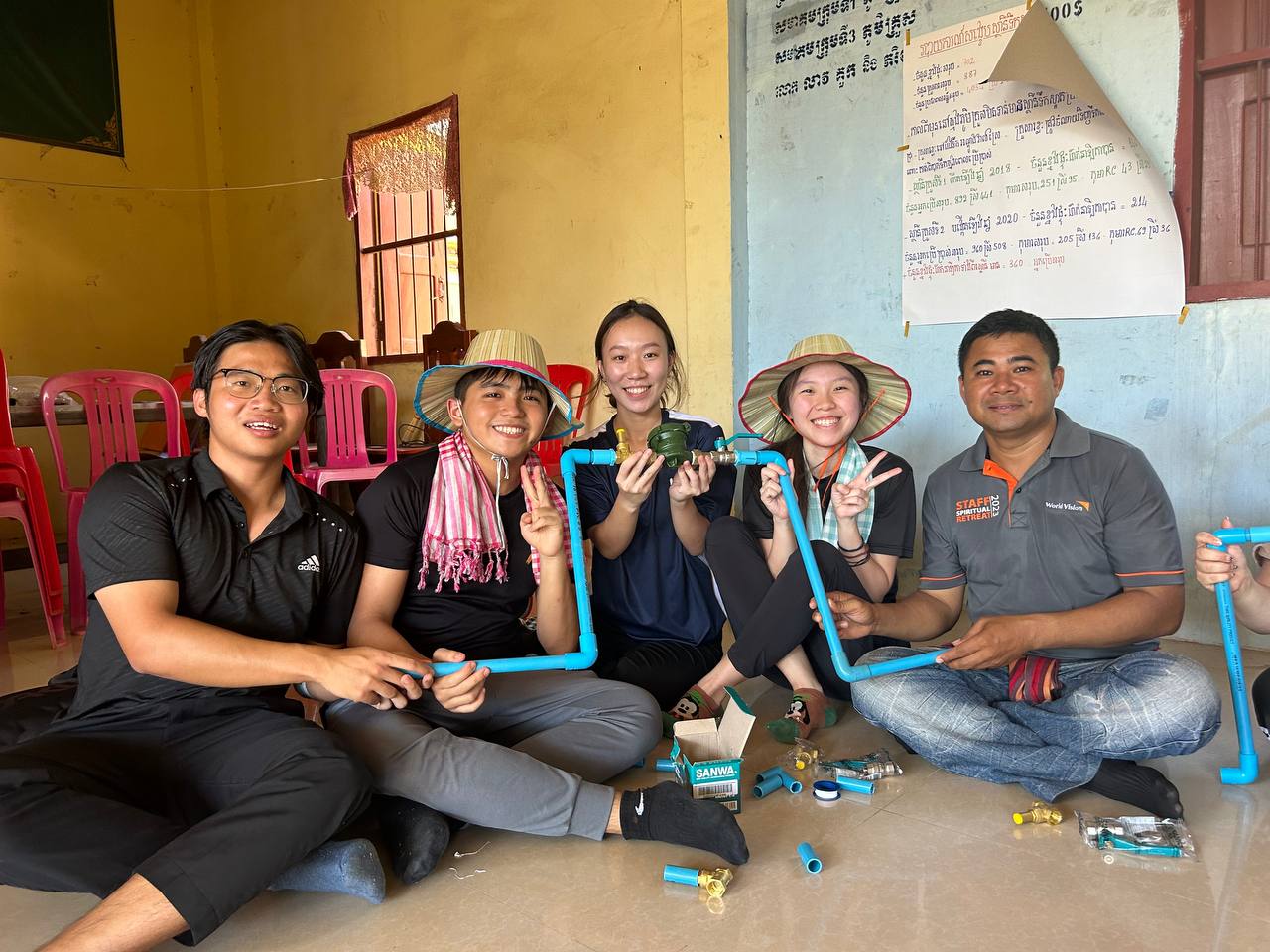 World Vision staff and SMU trippers hold up pipes